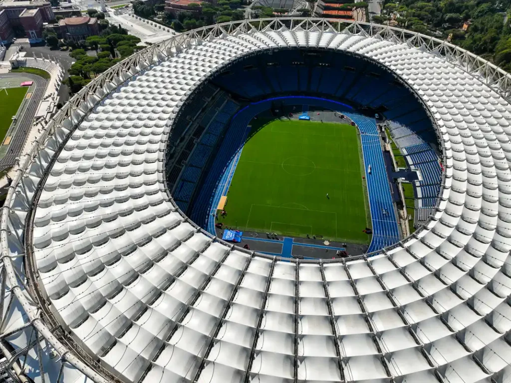 Nasycone kolory błękitnych trybun i zielonej trawy Stadio Olimpico widoczne z góry w jasny, słoneczny dzień